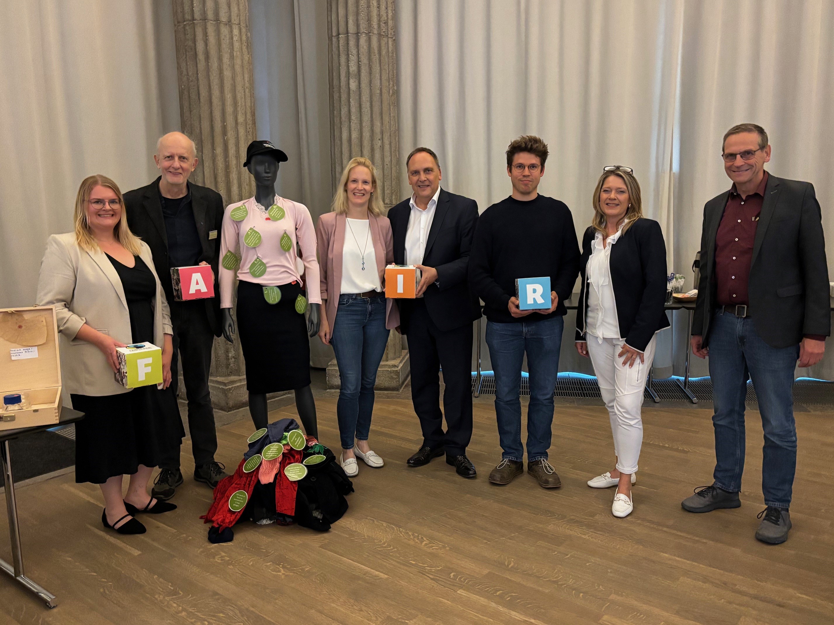 Öffnet die Seite 'Die wahren Kosten der Mode' Gemeinsam für nachhaltiges Handeln (von links): Anna Möller, Dr. Helmut Francke, Erste Kreisbeigeordnete Bir-git Weckler, Bürgermeister Klaus Kreß, Klimaschutzko-ordinator beim Wetteraukreis Jonas Bielke, vhs-Leiterin Ann-Karin Schild und Dr. Jürgen Roth.